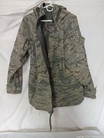 Front view of camouflage parka showing the zipper, hood, and pocket details