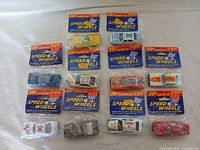 Top-down view of all 10 boxed Speed Wheels die-cast cars arranged on a flat surface showing original packaging and variety of colors and designs.