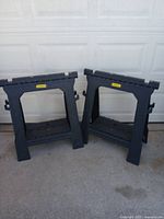 Photo of two black Stanley plastic sawhorses standing side by side
