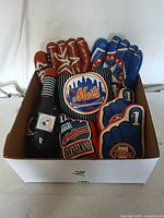 Wide top view of box containing assorted vinyl and plush baseball souvenir toys representing various MLB teams.