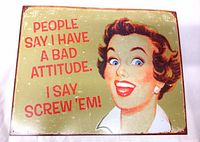 Photo showing the front side of the vintage metal sign with woman illustration and text 'People say I have a bad attitude. I say screw 'em!'.