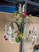 White metal floral chandelier with painted green leaves and pink and yellow flowers, six candle-style sockets