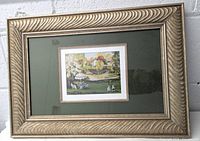 Photo of the entire framed print hanging on a wall, showing the frame's style and colors.
