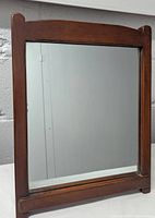 Front view of the rectangular tabletop mirror showing the dark wooden frame and the reflective glass surface.