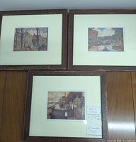 Three framed vintage prints displayed on wooden floor, showing overall condition and framing
