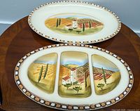 Photo of two Villa De Sienna hand painted serving dishes: an oval platter and a divided serving dish, showing Tuscan vineyard and cottage scene with decorative border.