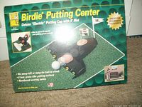 Photo of original Birdie Putting Center box featuring the electric putting cup and green putting mat on graphic cover.