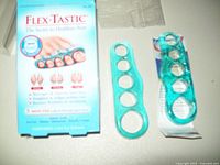 Set of Flex-Tastic gel toe exerciser pads displayed alongside the original packaging box showing product name and images of the exerciser on toes.