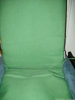 Front view of green fabric one-piece chair pad installed on a chair showing seat and backrest surfaces fully covered with padded cushion.