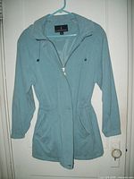 Front view of the blue London Fog women's rain jacket showing zipper, snap closure, pockets, and dolman sleeves