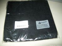 Folded black pillow covers in plastic packaging with barcode and warning label visible.