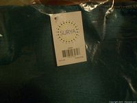 Label on pillow cover showing brand Surya, size 18 x 18, color turquoise