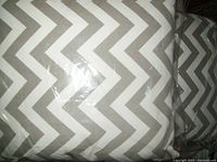 Close-up of gray and white chevron zigzag pattern on pillow cover, showing fabric texture and pattern