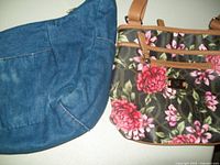 Floral pocketbook and denim slouch bag inside each other shown from the side