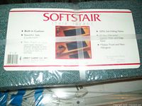 Two packages of SoftStair carpet stair treads wrapped in plastic with product label showing features and dimensions.