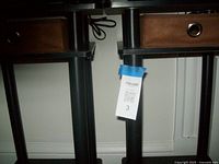 Close up of the soft cloth drawers and legs of two small end tables placed side by side showing grommet handles and black support legs.