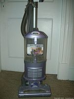 Front view of Shark Navigator upright vacuum cleaner showing brand and dust bin with 'never loses suction' sticker.