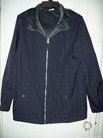 Front view of the reversible women's coat showing the black water repellent side with zipper and collar lined with gray faux fur.