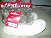 Photo showing side view of white fleece bootie slipper with gray faux fur cuff and red Dearfoam tag attached.