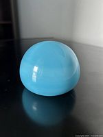 Paperweight on black surface showing side profile and color