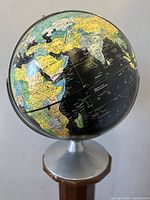Globe angled to show parts of Africa, Europe, and the Middle East with black ocean backing and colorful continental countries