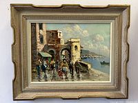 Full view of vintage Italian coastal scene oil painting in carved wooden frame, showing people walking near stone buildings and waterfront.