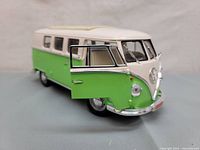 Front angle of the green/white VW Kombi diecast model with driver door open showing interior details.