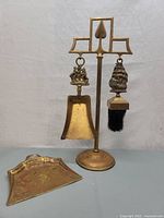 Full set showing brass stand with hanging shovel and brush, and dustpan in front.