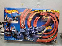 Front view of Hot Wheels Serpent Cyclone box showing large serpent-themed looping racing track and motorized launcher.