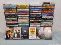 Front view of stacked music cassette tapes with artist names visible