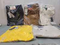 Five packed U.S. Polo Assn. clothing items on a flat surface showcasing shirts and pants.