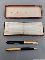 Top view of Waterman Taperite Crusader fountain pen and pencil set with original red case, showing lined interior and writing instruments placed outside the box.