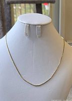 Chain displayed on white jewelry bust showing overall drape and length