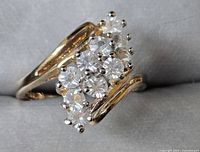 Close-up of the ring top showing the cluster of clear round stones and gold-tone setting.