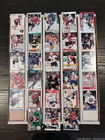 Top view of hockey trading cards sorted and organized in rows inside white storage boxes. Cards feature various NHL players from multiple card series primarily from 1990s to 2019.