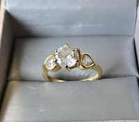 Front view of gold-tone ring with central round clear stone and 2 pear-shaped clear stones on sides, size 10.