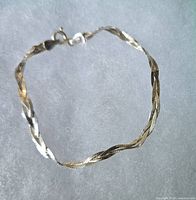 Full view of the silver twisted bracelet showing the clasp and overall design.