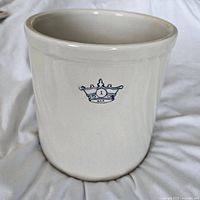 Front and side view of white ceramic crock showing Blue Crown #1 logo in blue ink. Shows smooth glossy surface and cylindrical shape.