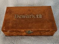 Brown wooden box with Dewar's 12 embossed on lid and metal clasp