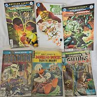Photo showing six vintage comic books including Green Lantern Corps, Batman Movie Special, Donald Duck, and Chamber of Chills.