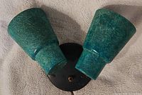 Top angle showing two turquoise textured glass shades on a black circular base with visible wear.