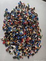 Overhead view of approximately 350 assorted LEGO minifigures on a white surface