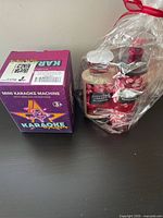 Photo of boxed mini karaoke machine and plastic wrapped Bath & Body Works Japanese Cherry Blossom fragrance set.