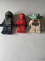 Three LEGO figure items: black ninja digital clock, red ninja digital clock, and Yoda flashlight.