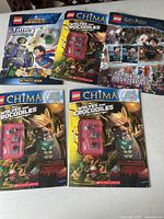 Five LEGO themed activity books including Harry Potter, DC Super Heroes, and LEGO Chima, showing front covers and some accessory pieces.