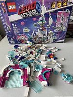 LEGO pieces from set 70838 laid out partially assembled alongside original box featuring space ship from The LEGO Movie 2.