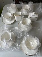 Photo showing full set on table with plastic wrapping on several pieces