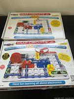 Front and top side views of the Snap Circuits Jr. box showing branding and project count.