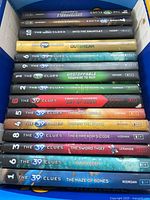 Top down view of the 15 hardcover books stacked horizontally showing various titles and colorful spines.