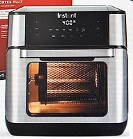 Front view of Instant Vortex Plus air fryer oven showing digital screen and rotisserie basket through glass window.